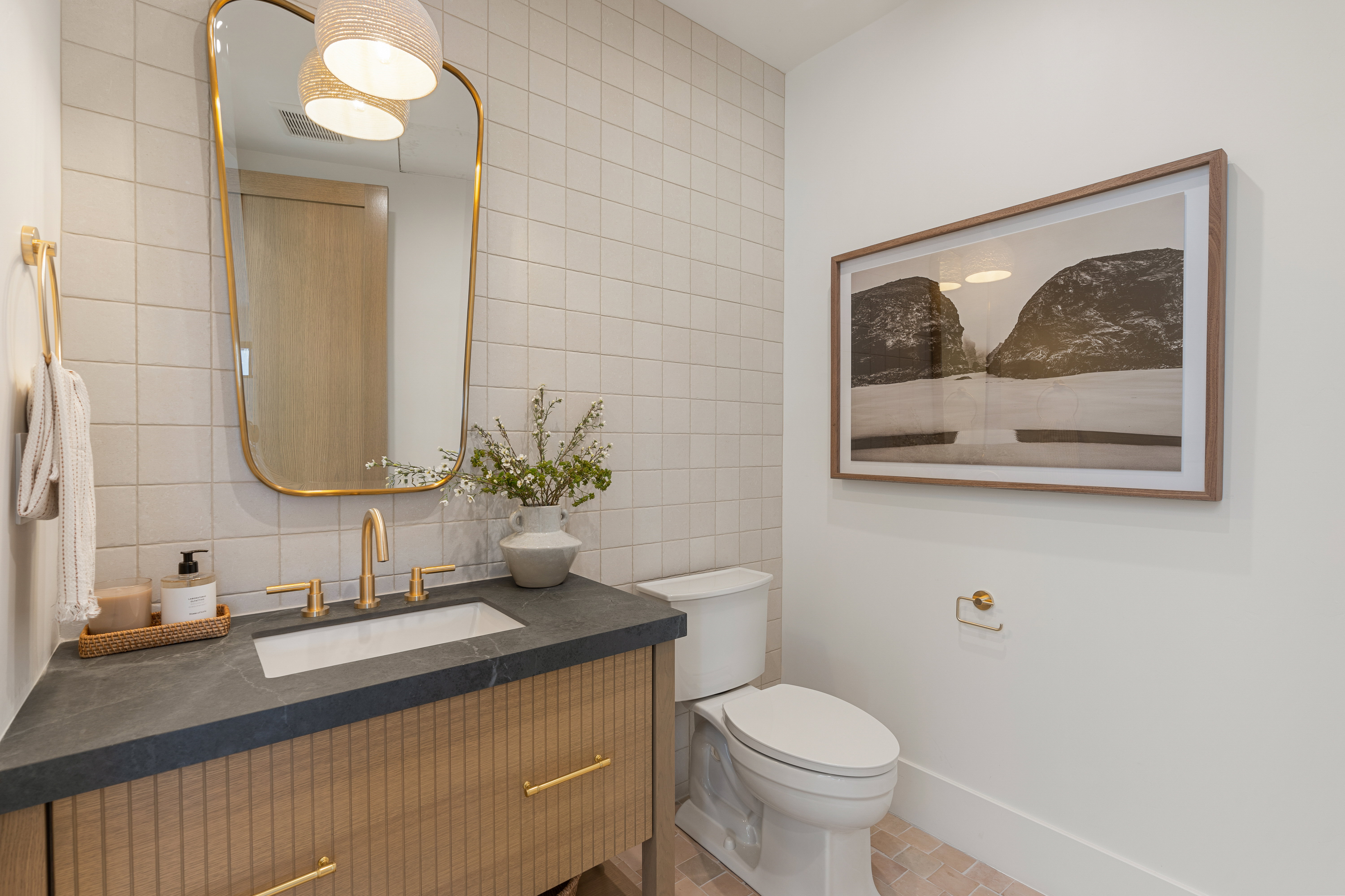 Half bathroom with tile walls, vanity, decorative backsplash, and light tile patterned floors