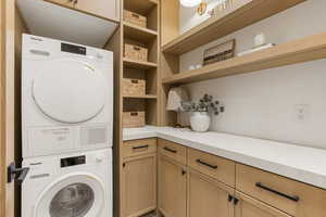 Laundry room with cabinet space and stacked washer and dryer