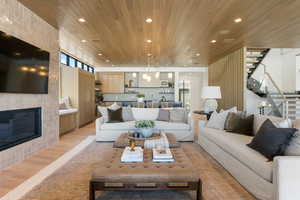 Living area with light wood-style flooring, a large fireplace, plenty of natural light, recessed lighting, and wood ceiling