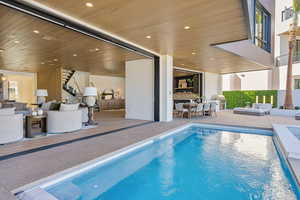 Indoor pool with a patio and outdoor lounge area