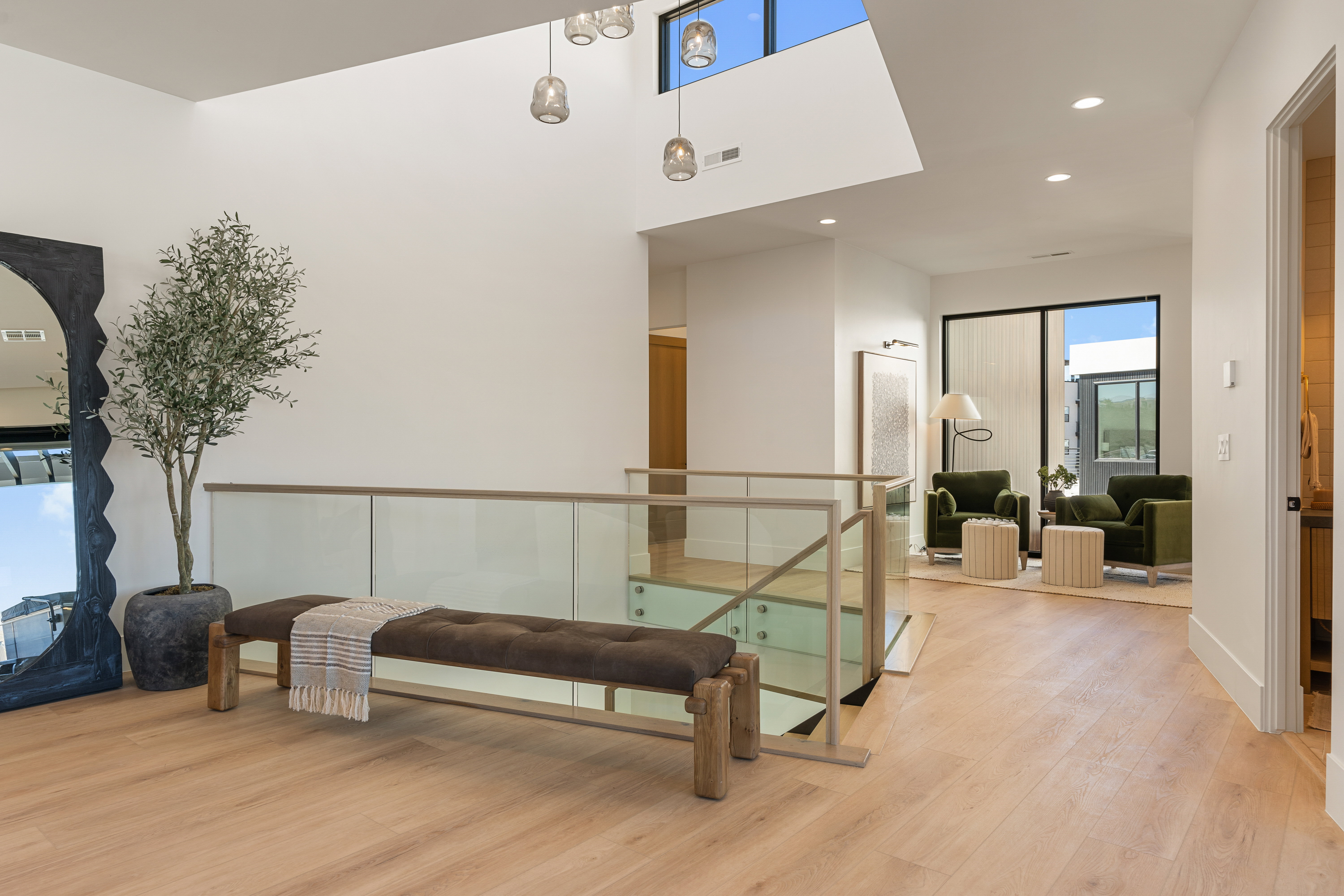Corridor featuring light wood-style floors, recessed lighting, a high ceiling, and an upstairs landing
