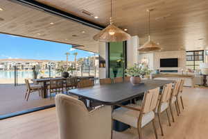Dining area featuring floor to ceiling windows, light wood-style flooring, wooden ceiling, a residential view, and recessed lighting