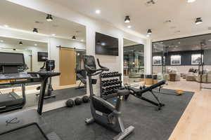 Exercise room with a barn door and recessed lighting