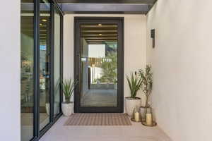 Doorway to property featuring stucco siding