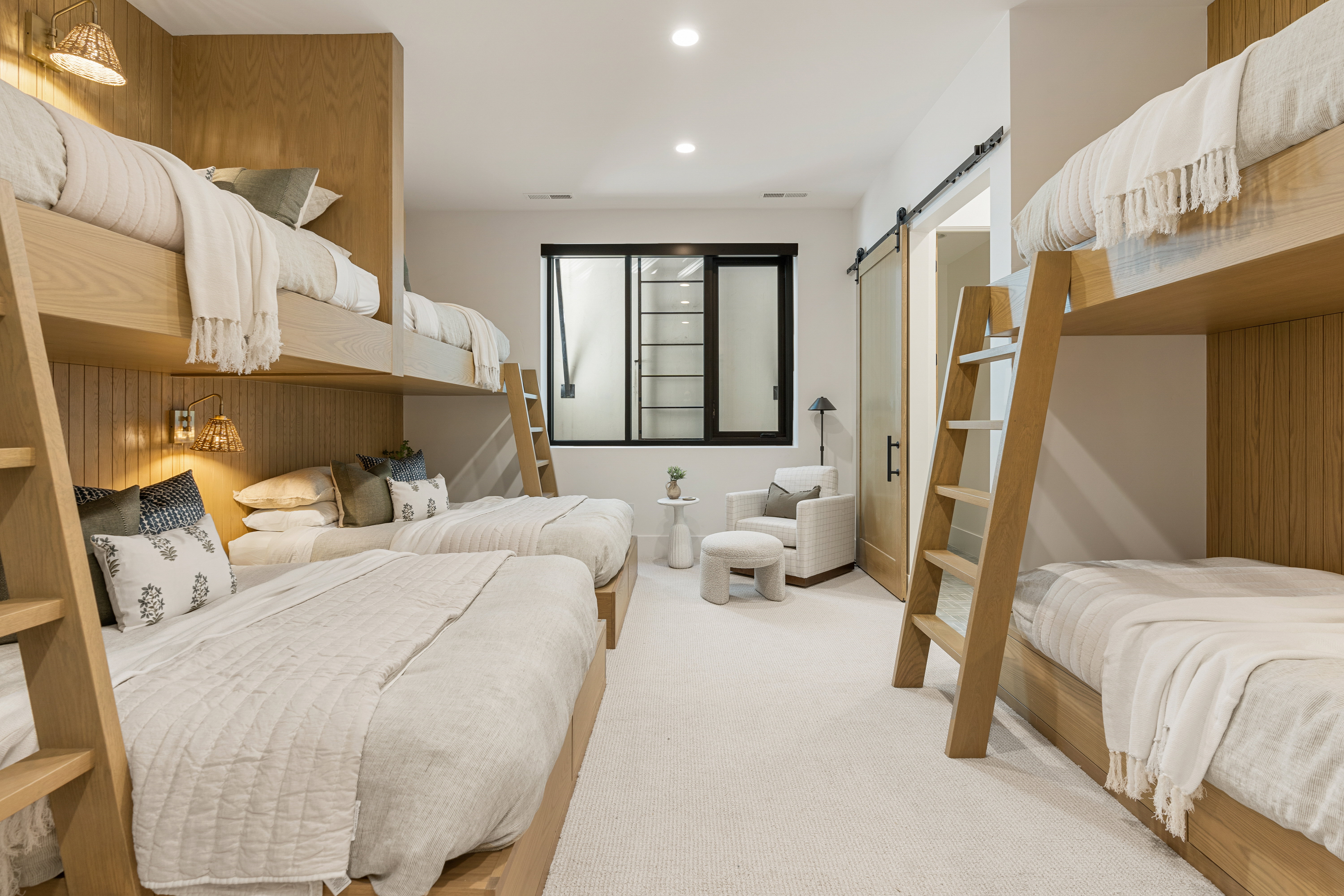 Carpeted bedroom with a barn door and recessed lighting