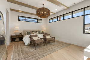 Bedroom featuring light wood-type flooring, recessed lighting, beamed ceiling, and a closet