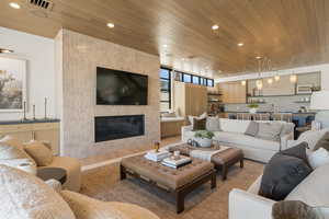 Living area featuring wooden ceiling, a large fireplace, and recessed lighting
