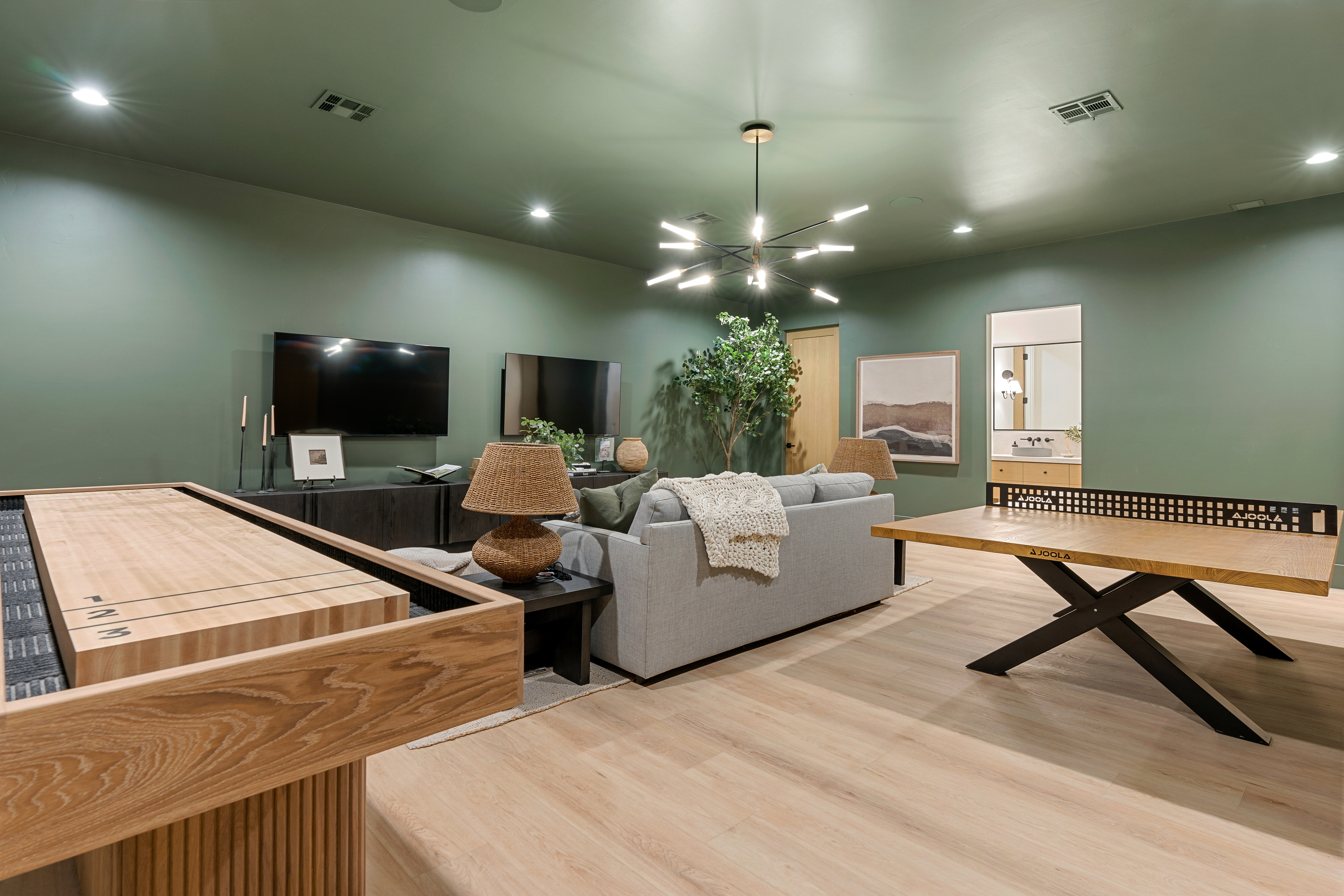 Living area with suspended lighting and light wood-style floors