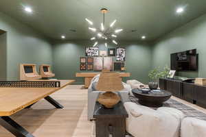 Rec room with suspended lighting and wood finished floors