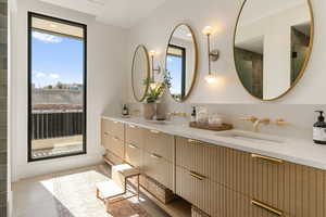 Bathroom featuring double vanity and healthy amount of natural light
