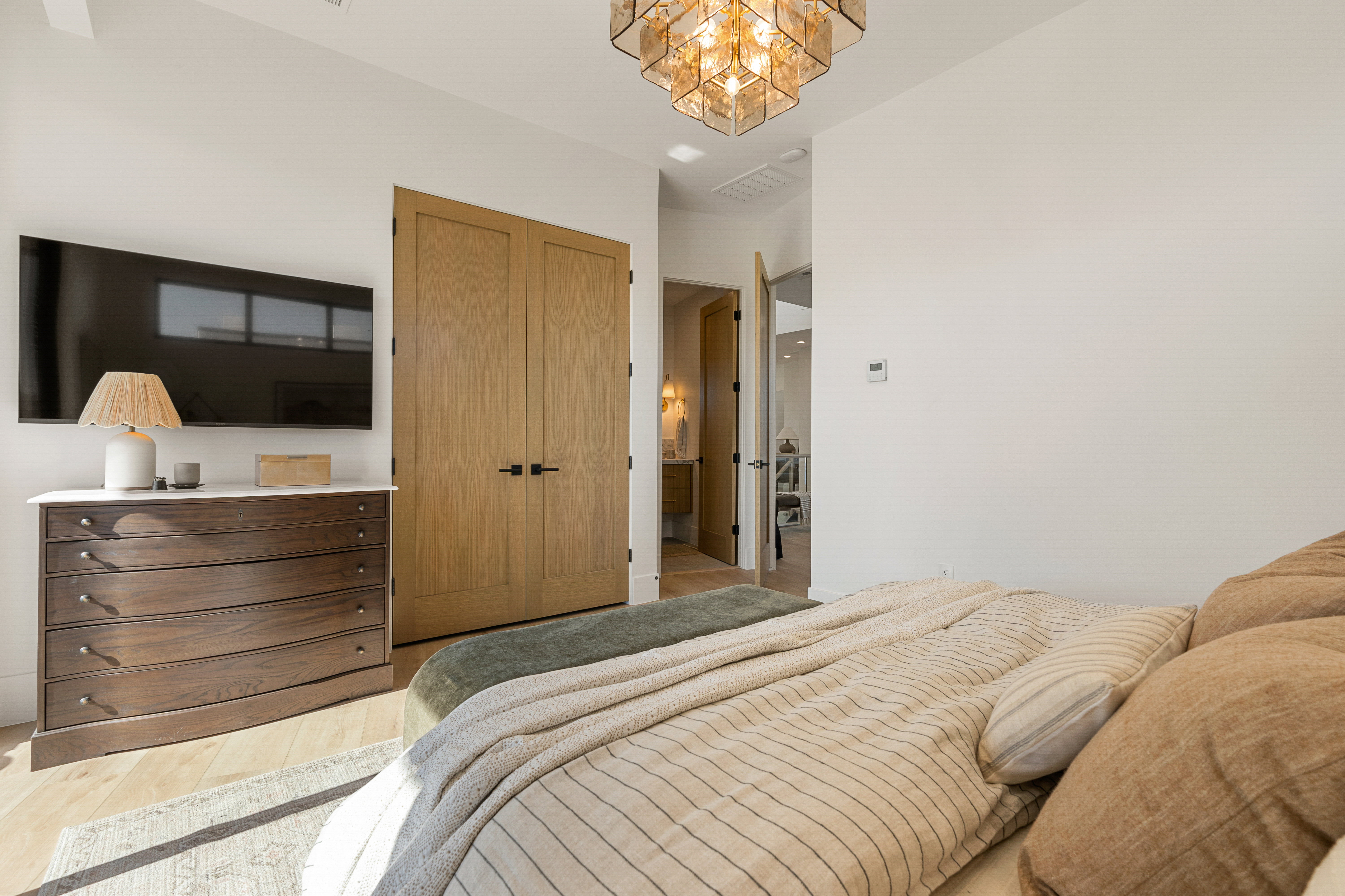 Bedroom featuring a closet, light wood-style flooring, and a chandelier