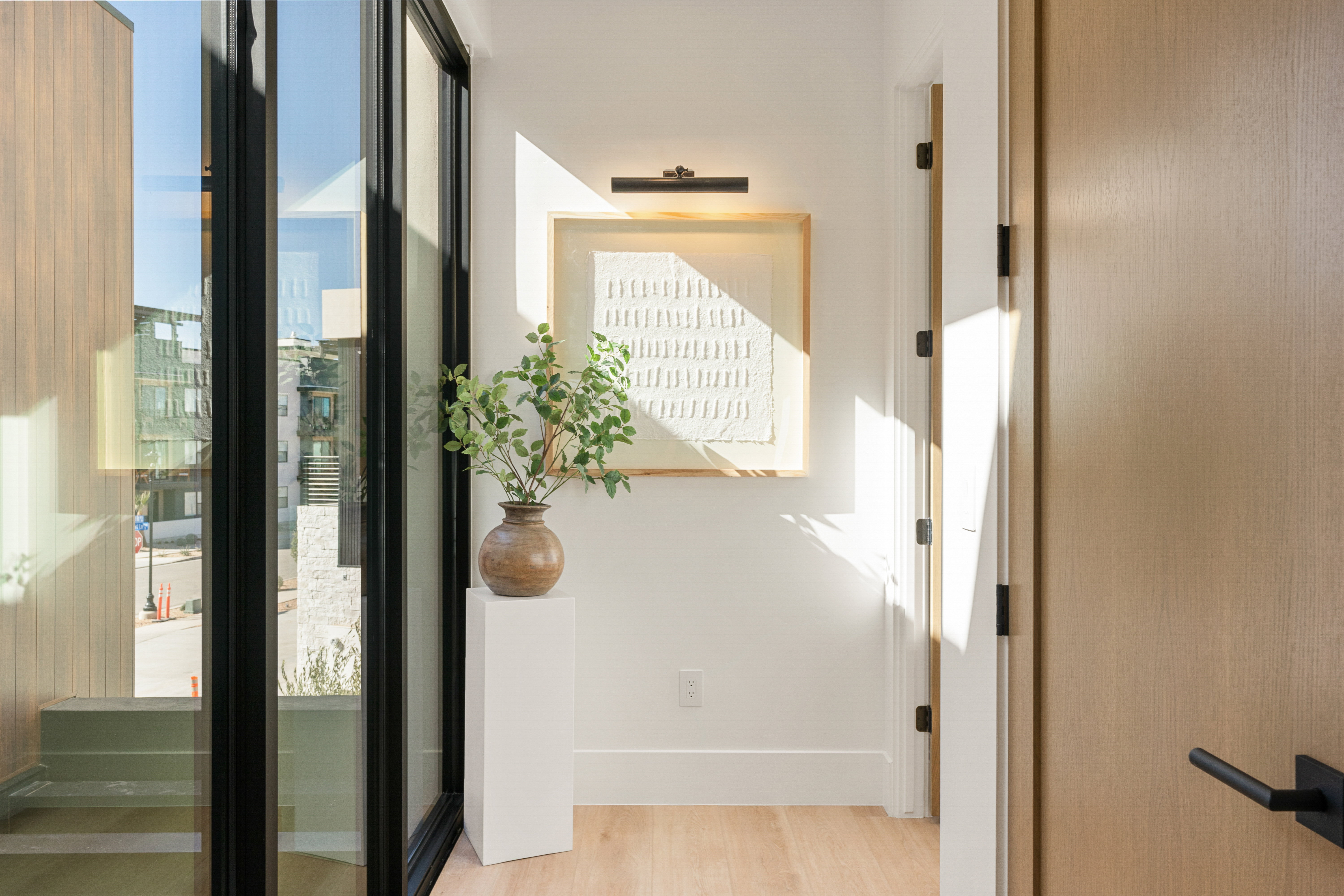 Corridor featuring light wood finished floors and healthy amount of natural light