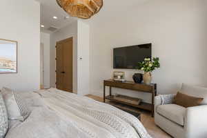 Bedroom with wood finished floors, recessed lighting, and a closet