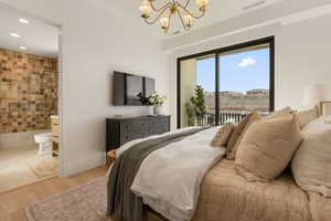 Bedroom featuring access to exterior, suspended lighting, and light wood finished floors
