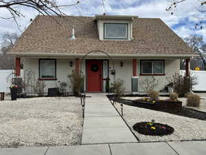 View of front of property with roof with shingles, stucco siding, and a porch