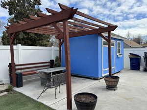 Fenced backyard featuring a patio area and shed