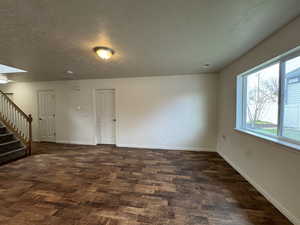 Living room featuring a textured ceiling and dark wood-style flooring