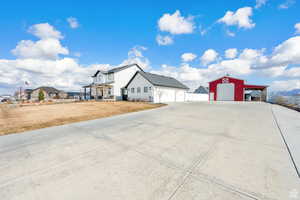 View of home's exterior featuring a detached garage, covered porch, a residential view, an outdoor structure, and driveway
