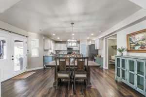 Dining area with dark wood-style floors, recessed lighting, and french doors