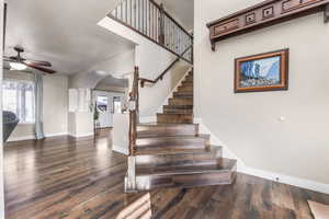 Stairway with wood finished floors, arched walkways, and ceiling fan