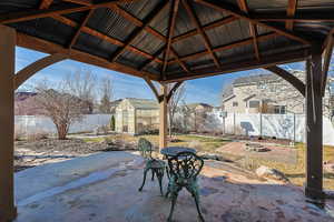 Fenced backyard featuring an exterior structure, a fire pit, an outbuilding, a patio area, and a residential view