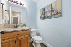 Half bath with vanity and dark wood-style flooring