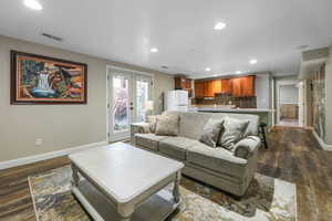 Living area featuring dark wood-type flooring, french doors, and recessed lighting