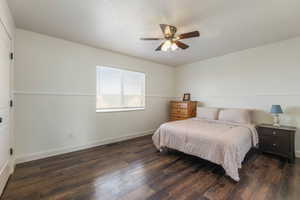 Bedroom with dark wood finished floors and ceiling fan