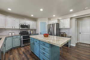 Kitchen featuring two tone cabinets, stainless steel appliances, tasteful backsplash, dark wood-style floors, and recessed lighting