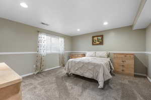 Bedroom with light carpet and recessed lighting