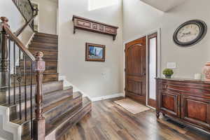 Foyer featuring dark wood-type flooring and stairway