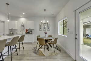 Dining space with light wood-style flooring and a chandelier