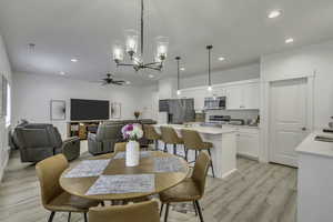 Dining room featuring hanging lights, light wood-style floors, and ceiling fan