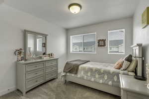 Bedroom featuring multiple windows and light carpet
