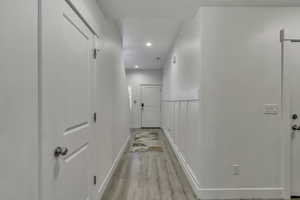 Corridor with recessed lighting and light wood finished floors