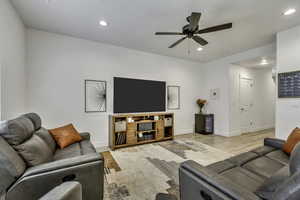 Living room featuring a ceiling fan, light wood finished floors, and recessed lighting