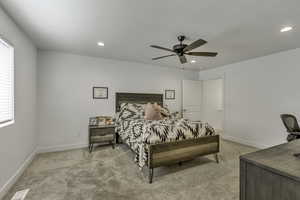 Bedroom with a ceiling fan, light colored carpet, and recessed lighting