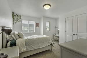 Bedroom featuring light carpet and a closet