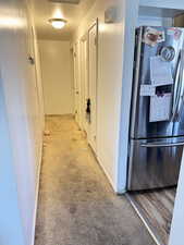 Hallway featuring light colored carpet and baseboards