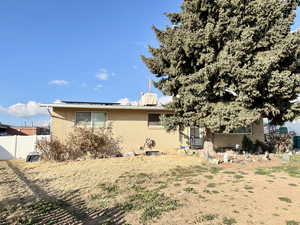 Rear view of house featuring brick siding and roof mounted solar panels