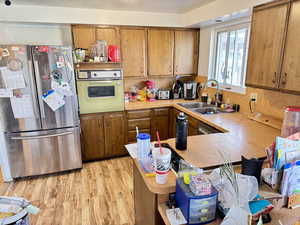 Kitchen with freestanding refrigerator, light countertops, and wood finish cabinets