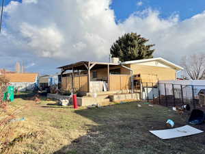 Back of house with brick siding, an outdoor structure, and a patio