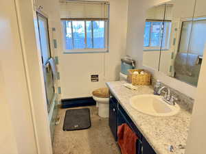 Full bathroom featuring vanity, plenty of natural light, and a baseboard radiator