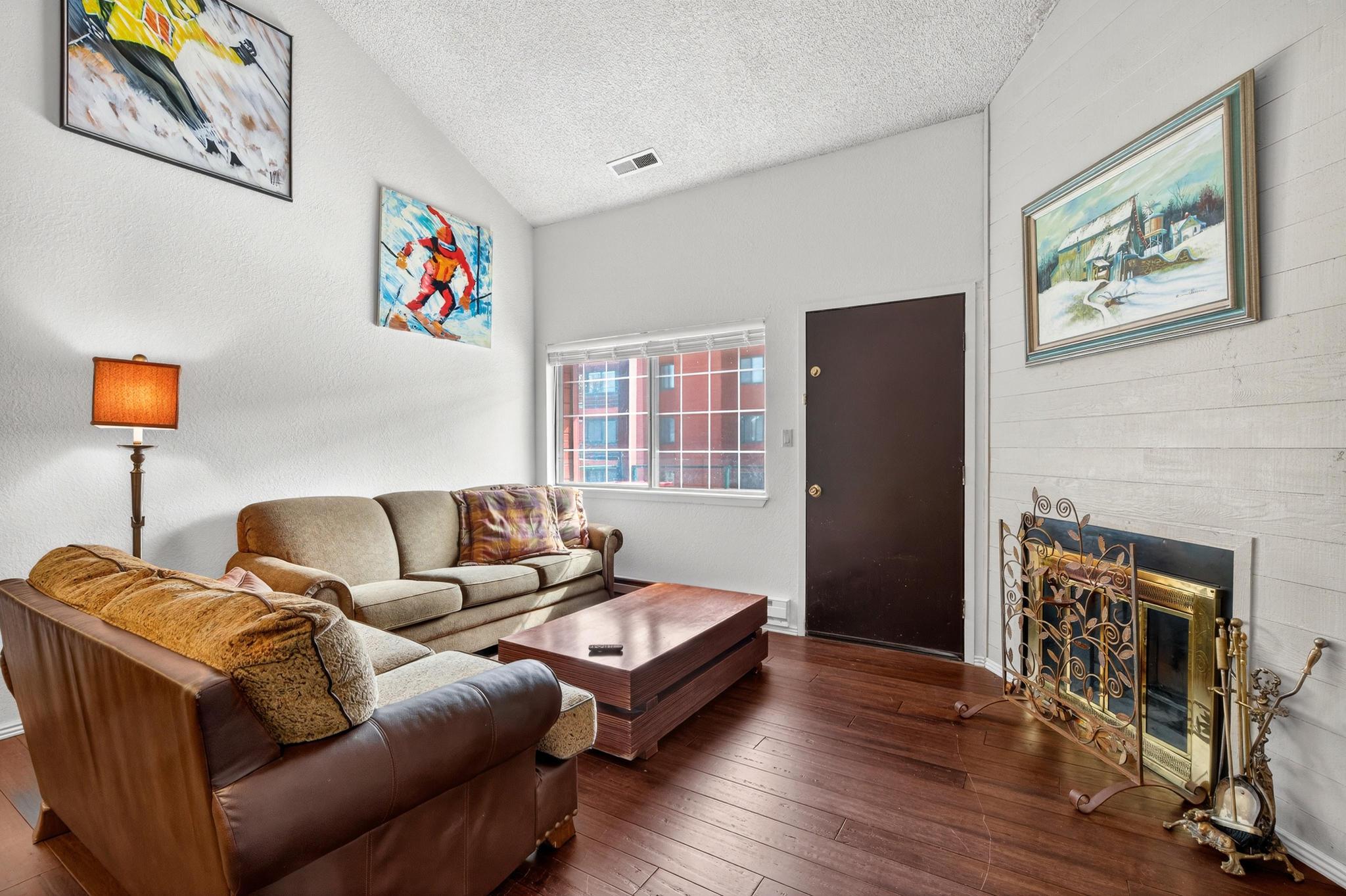 Living area featuring hardwood / wood-style flooring and a glass covered fireplace
