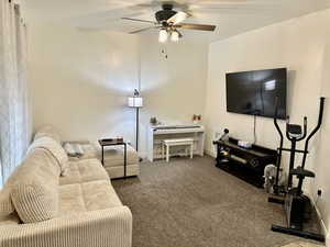 Living area featuring a ceiling fan and carpet floors