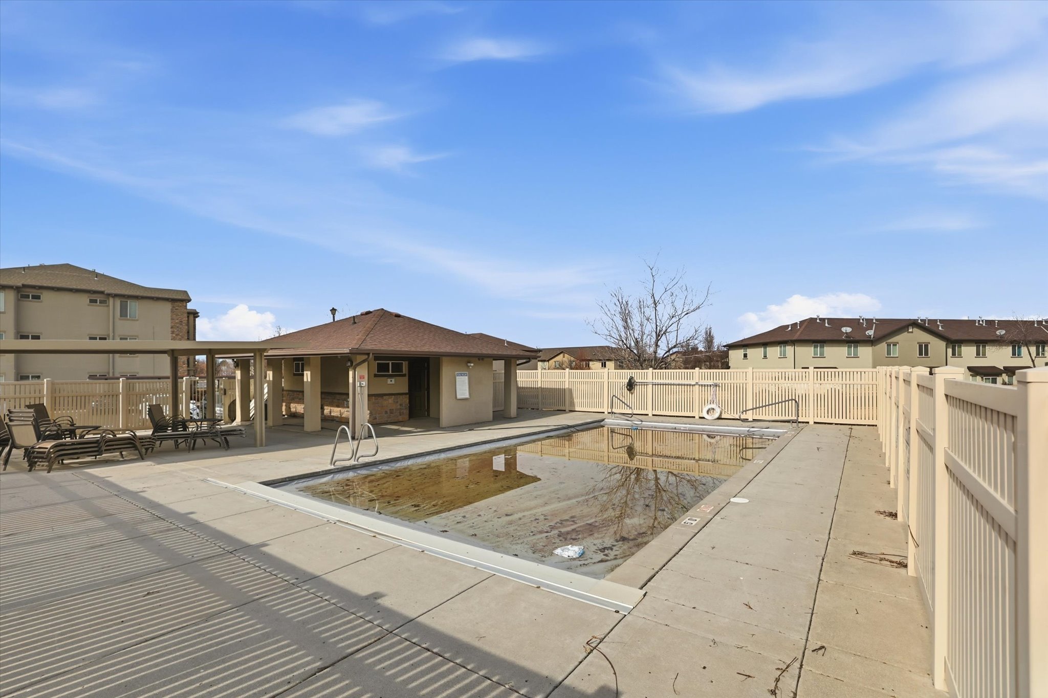 Community pool featuring a patio area, a residential view, and a fenced backyard