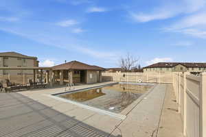 Community pool featuring a patio area, a residential view, and a fenced backyard