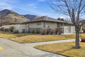 View of property clubhouse exterior with stucco siding, stone siding, a mountain view, and a shingled roof