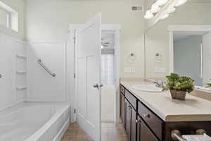 Primary Bedroom Private, Full bathroom with vanity, light tile patterned flooring, and shower / bath combination