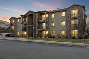 Property at dusk featuring a view of condominium building / complex
